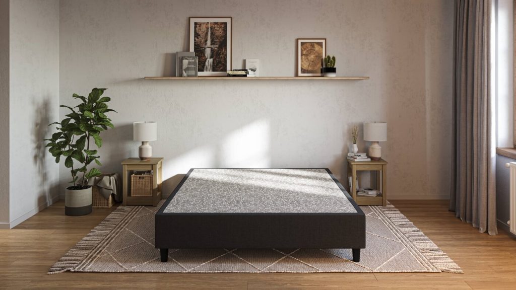 Foto que ilustra matéria sobre tipos de cama mostra uma cama box no meio de um quarto, sem colchão em cima