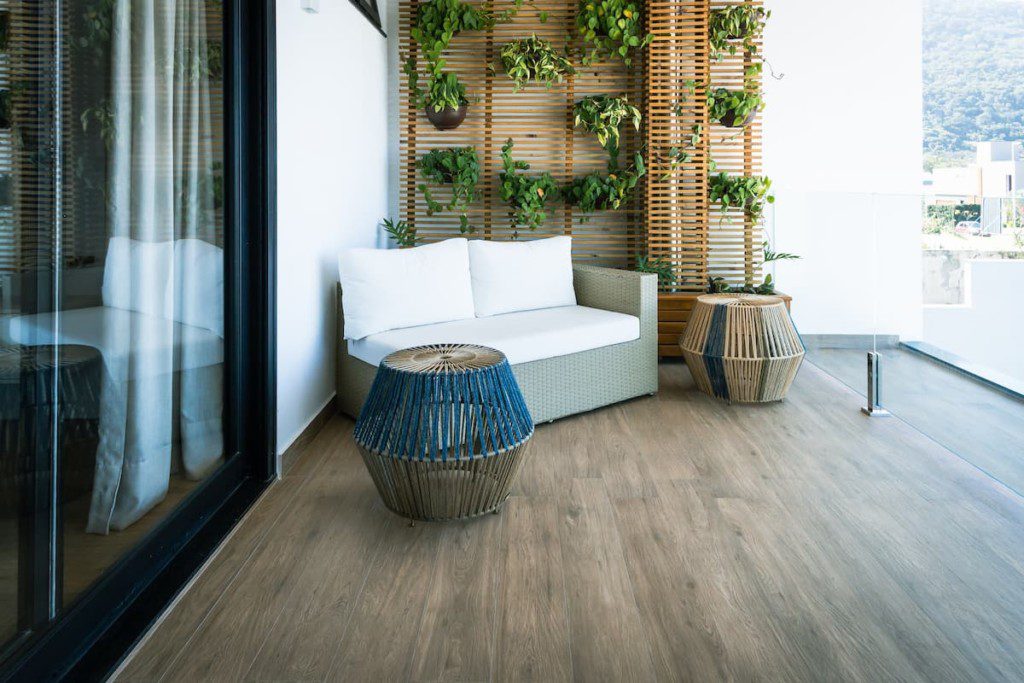 Varanda integrada com móveis resistentes ao sol e jardim vertical.