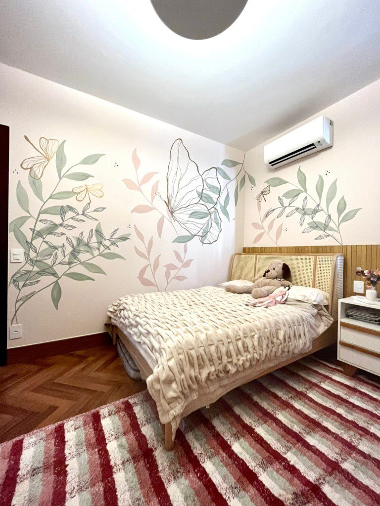 Quarto com cama de casal com paredes decoradas com pinturas florais feitas à mão.