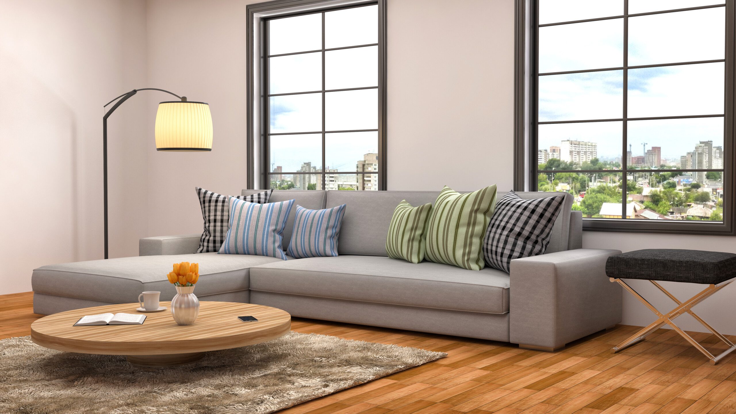 Sala de estar com sofá cinza, almofadas decorativas, tapete e mesa de centro de madeira. 