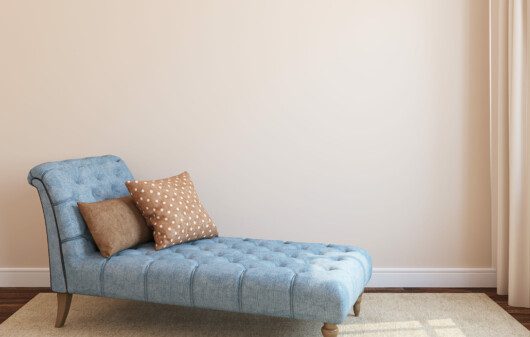Chaise lounge azul com almofadas marrom.