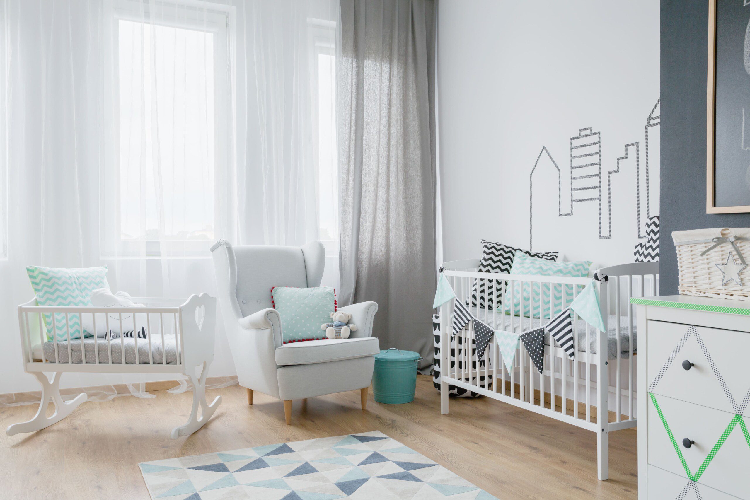 Imagem de um quarto de bebê clean com berço e poltrona de amamentação.