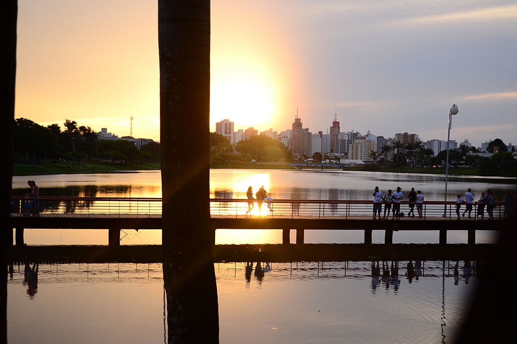 Foto que ilustra matéria sobre o Parque da Represa Municipal em São José do Rio Preto mostra o deck do lago com o sol se pondo ao fundo. 
