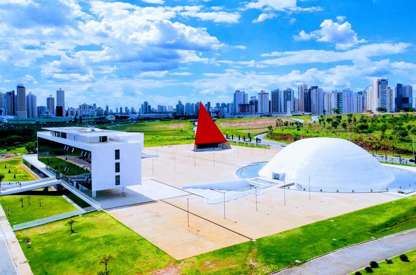 Foto que ilustra matéria sobre o Centro Cultural Oscar Niemeyer mostra o complexo visto de cima em um dia de céu azul com nuvens brancas ao fundo.
