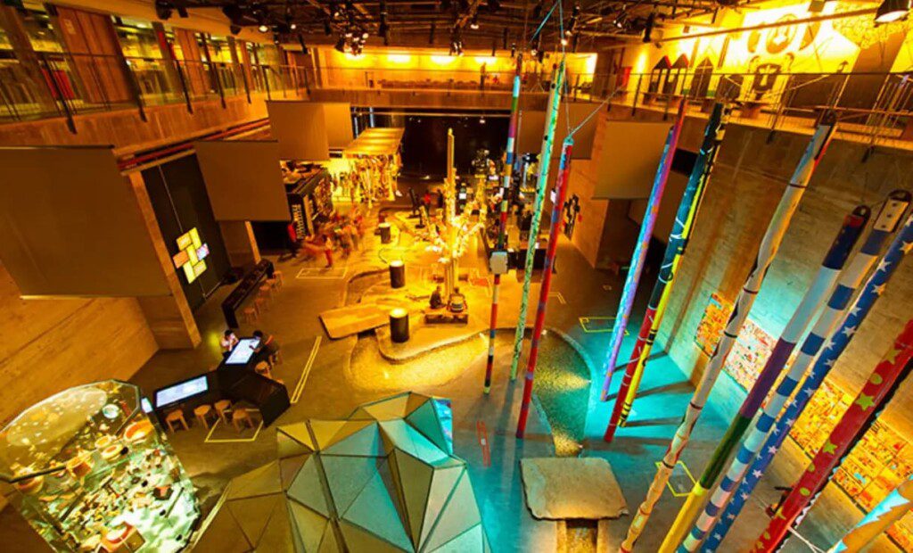 Imagem do interior do Centro Cultural Cais do Sertão. É possível ver um amplo salão com diversos objetos expostos.