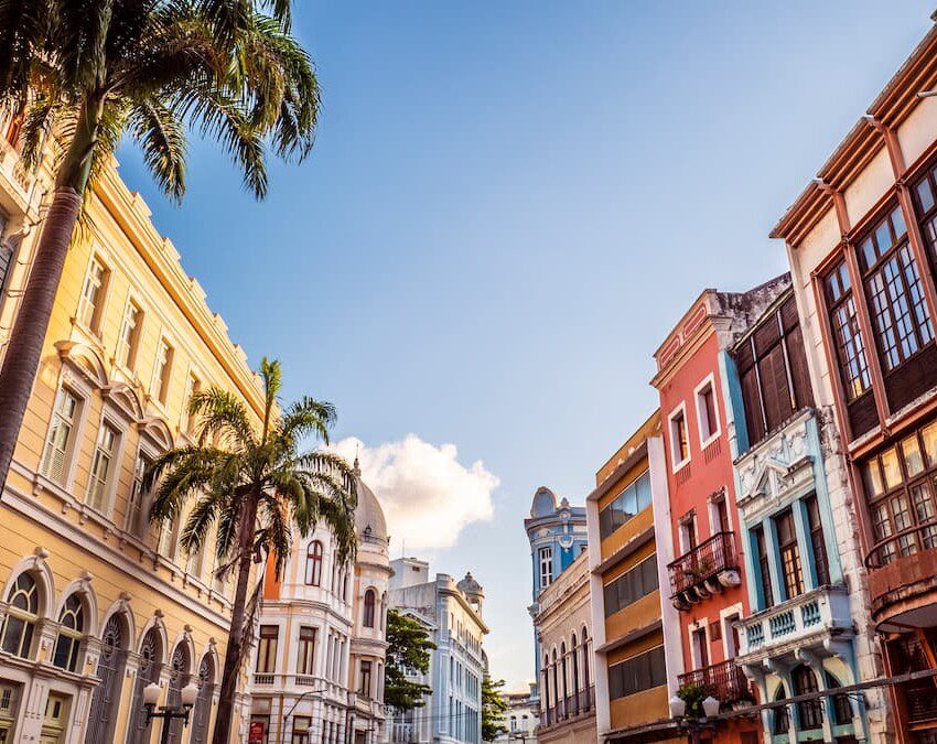 Prédios históricos, árvores e um céu azul fazem parte da paisagem desta fotografia do Centro Histórico de Recife.