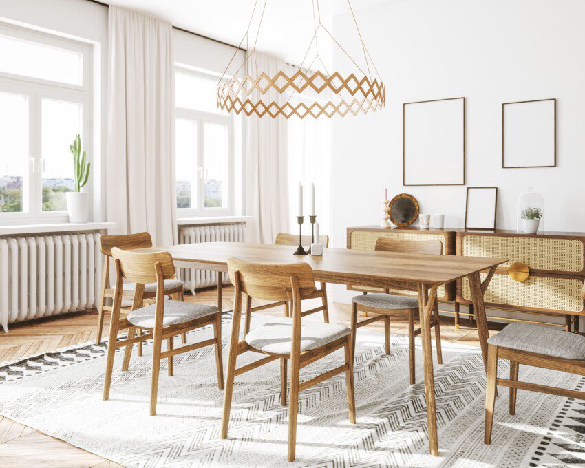 Mesa de jantar em madeira clara em um ambiente clean com paredes brancas, quadros e lustre.