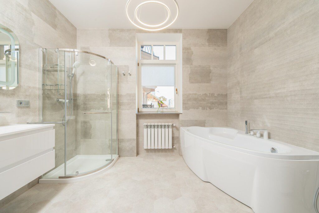 Banheiro clean em tons de bege, movéis branco e decoração clássica. 
