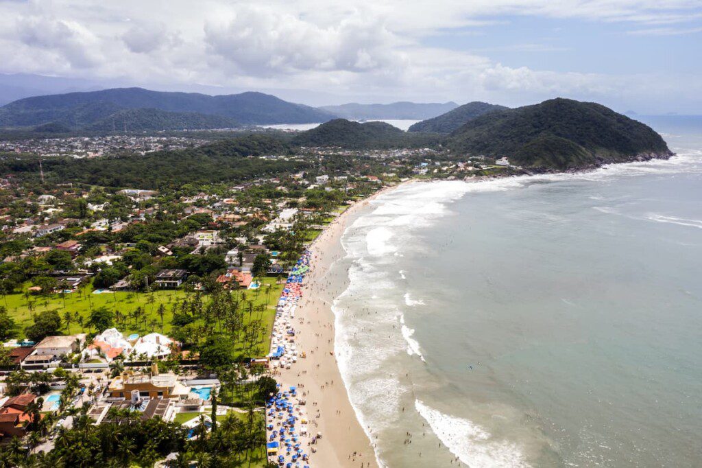 Imagem aérea da Praia de Pernambuco. É possível observar uma grande área verde próxima a faixa de areia.