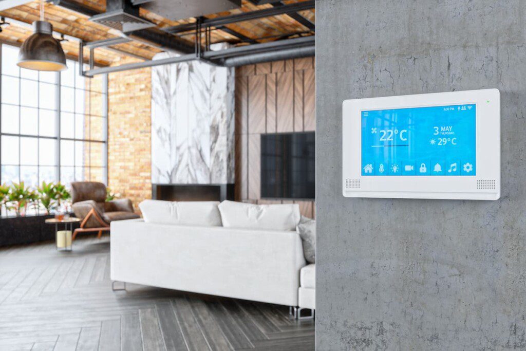 Imagem de uma sala de luxo, com destaque para um painel que controla eletrônicos da casa, como ar condicionado e outros.