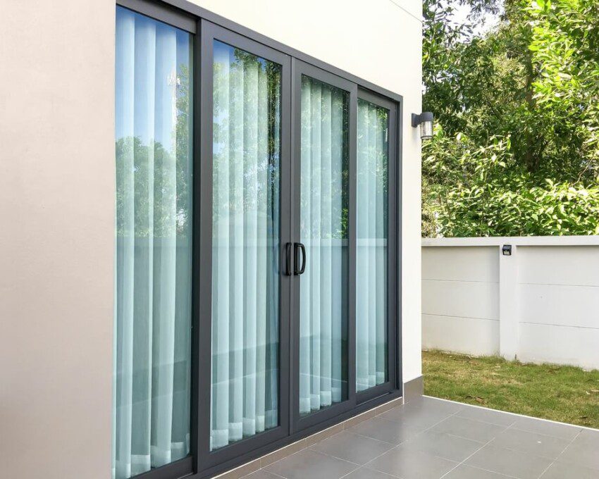 Foto que ilustra matéria sobre esquadria mostra um exemplo de uma porta de vidro que separa uma casa de seu ambiente externo