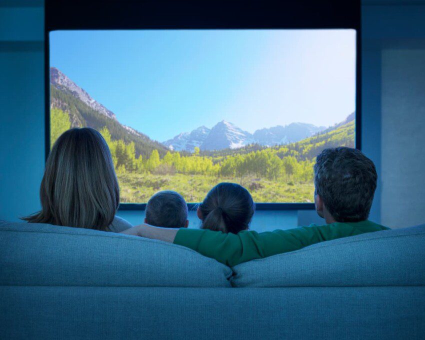 Família assiste filme na sala de cinema em casa.