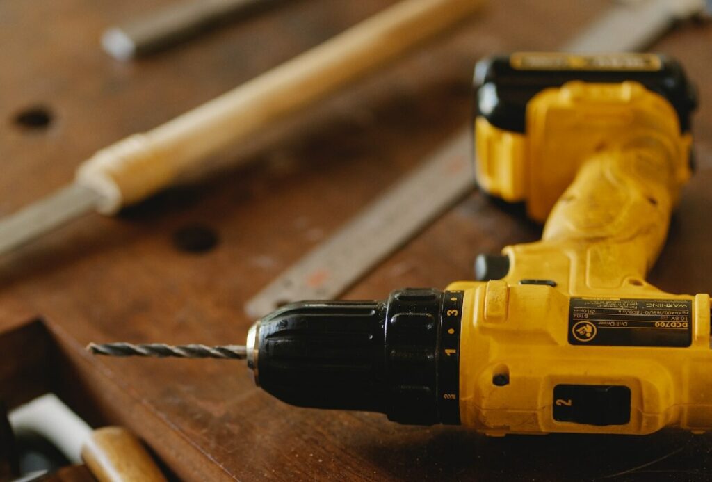 Foto que ilustra matéria sobre tipos de ferramentas mostra uma furadeira amarela.