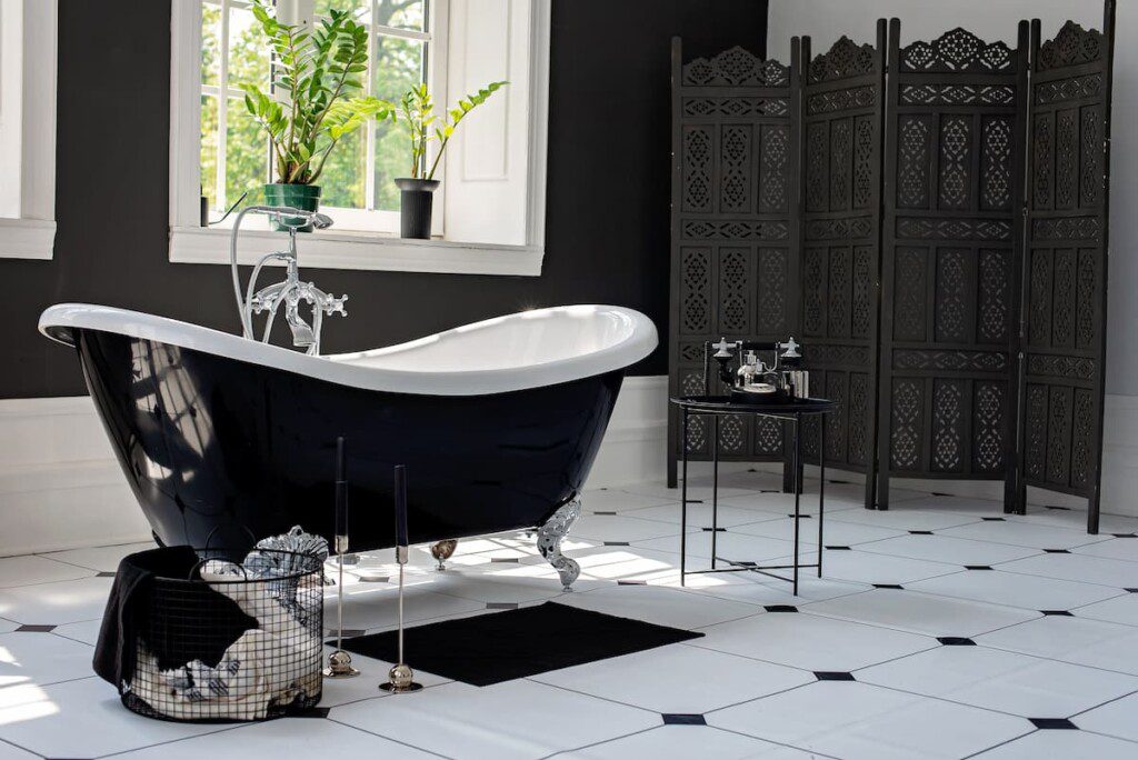 Banheiro revestido por cerâmica em preto e branco.