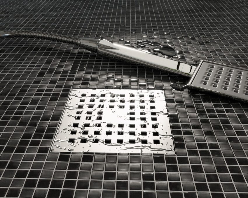 Imagem de um ralo de banheiro banheiro instalado em uma cerâmica quadriculada que mescla as cores preto e cinza para ilustrar matéria sobre o tema