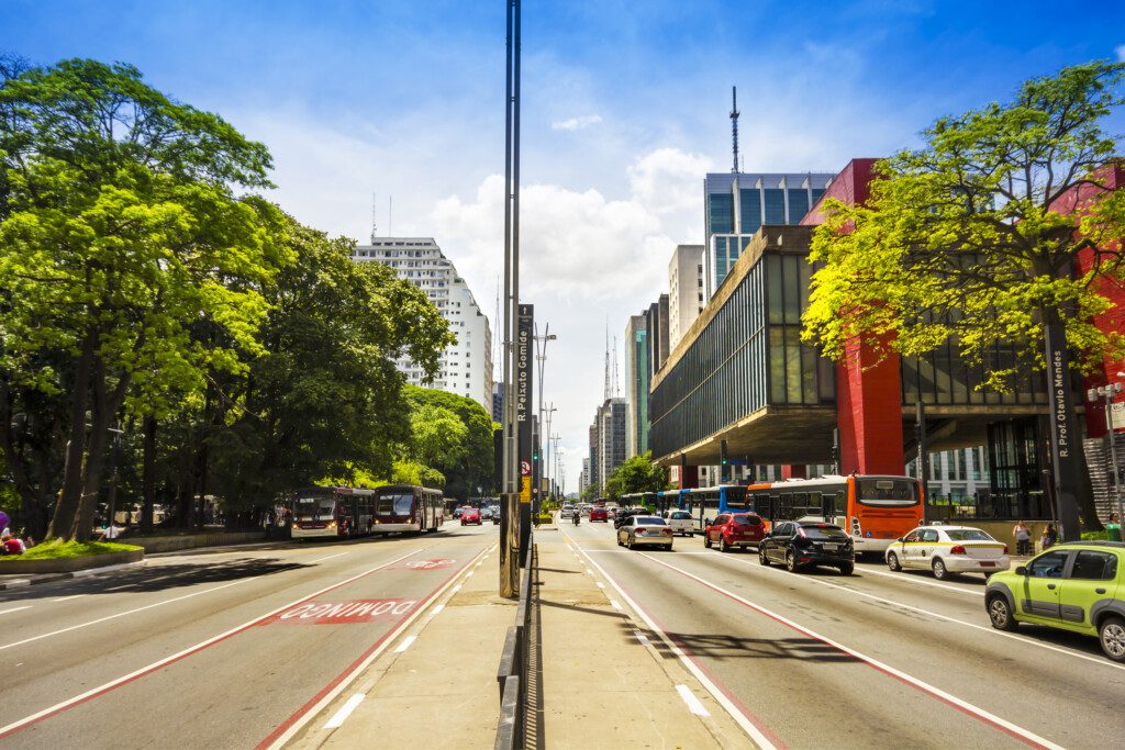 Imagem de carros passando na Avenida Paulista, em frente ao Museu de Arte de São Paulo