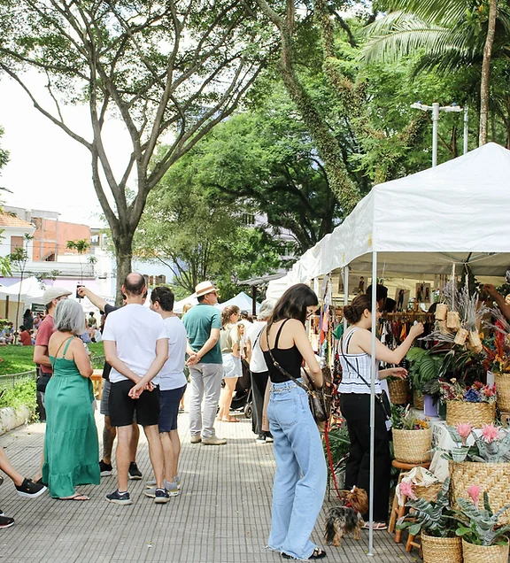 Imagem de pessoas conversando e observando os produtos vendidos na Feira Jardim Secreto, em São Paulo