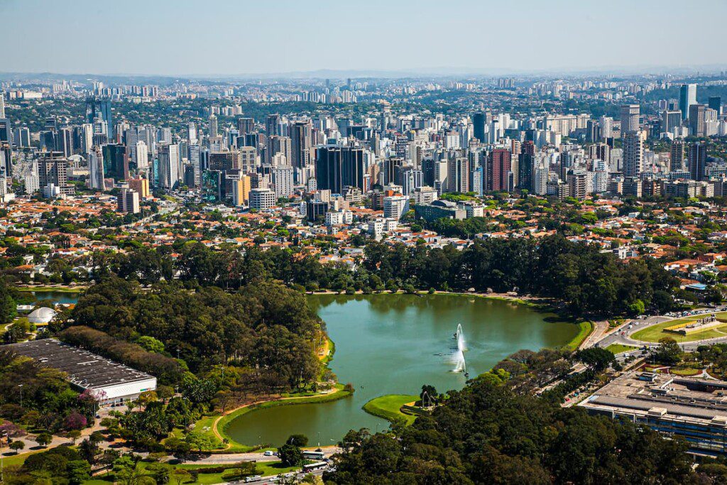 Imagem aérea da Cidade de São Paulo, com o Parque Ibirapuera em destaque, na parte inferior da foto.