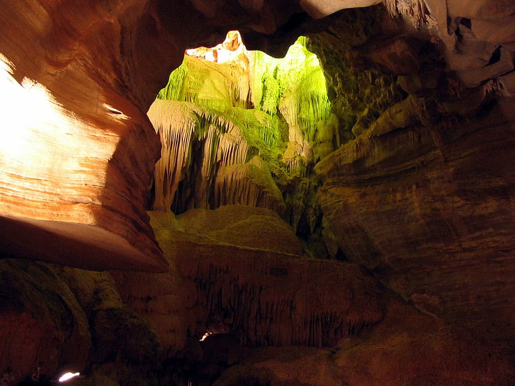 Imagem do interior de uma gruta, iluminada pelo sol.