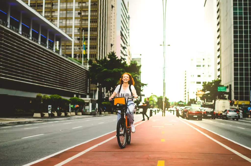 Garota ruiva andando de bicicleta na ciclofaixa da Avenida Paulista, em São Paulo.