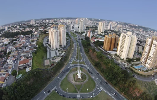 Imagem da vista aérea da cidade de Jundiaí com vias e prédios para ilustrar matéria sobre as vantagens e desvantagens de morar em Jundiaí, no interior de São Paulo