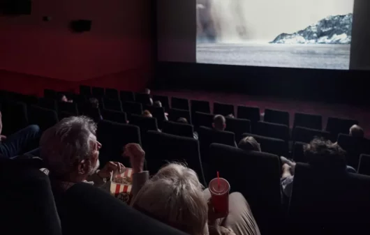 Pessoas assistindo um filme em uma sala de cinema em BH.