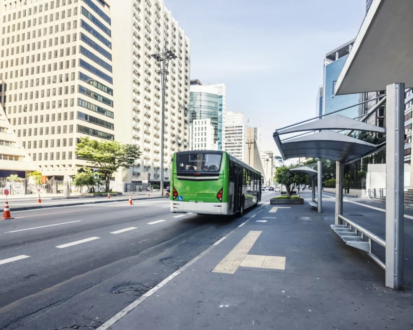 Imagem de uma parada de ônibus com um ônibus verde na Avenida Paulista, em São Paulo, para ilustrar matéria sobre cidades com o melhor transporte público do Brasil