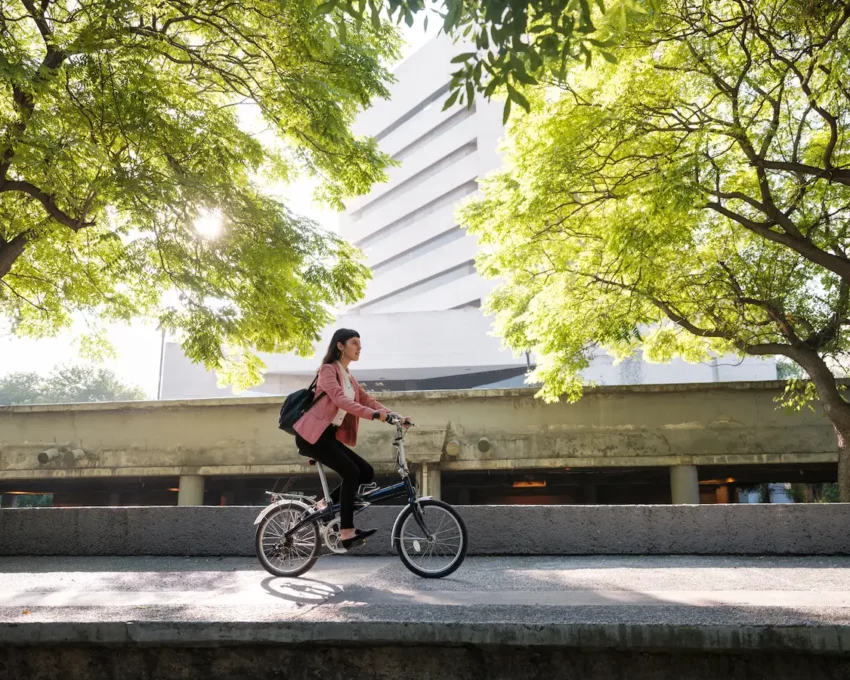 Uma mulher andando de bicicleta em uma cidade sustentável.