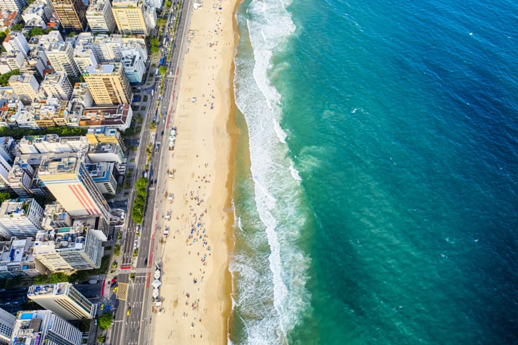Imagem aérea da praia de Ipanema mostra o mar, faixa de areia e prédios para ilustrar matéria sobre os bairros nobres do RJ