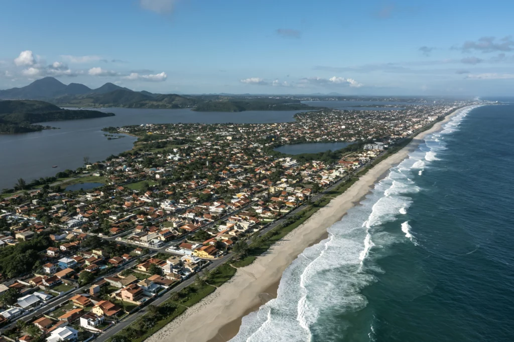 Imagem da vista aérea de Saquarema, no Rio de Janeiro, mostra mar, faixa de areia, vegetação e imóveis que compõem a região