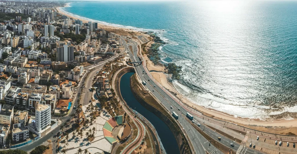 Imagem da vista aérea da costa de Salvador mostra mar, faixa da areia, avenidas e prédios para ilustrar matéria sobre a cidade mais rica da Bahia