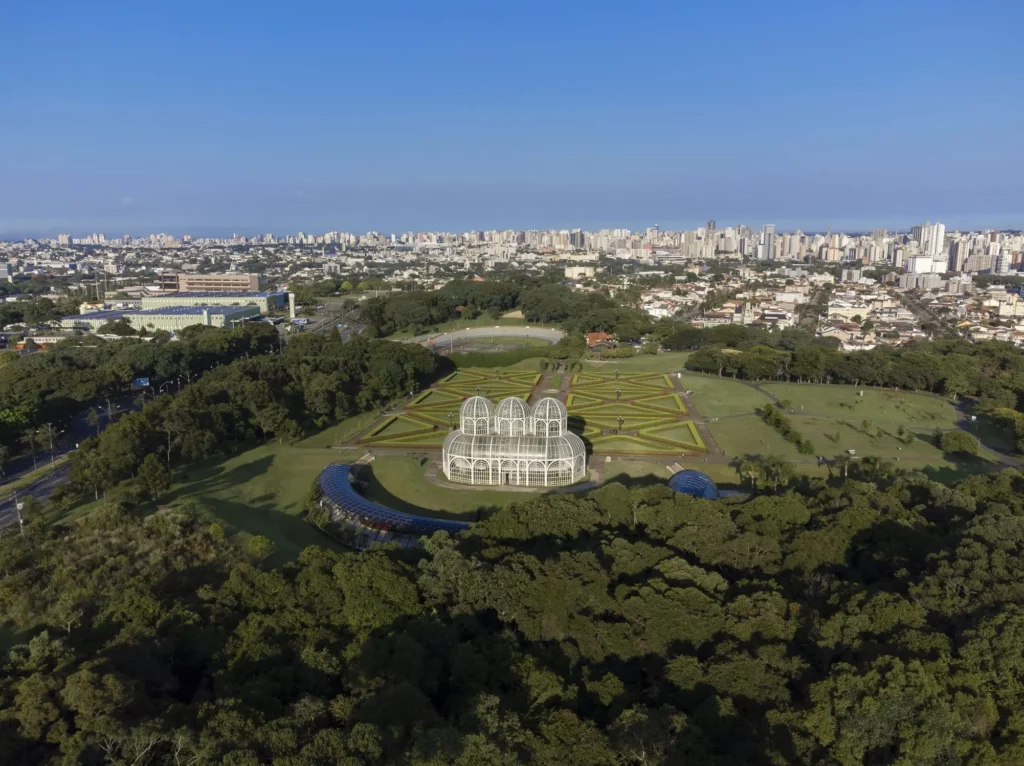 Imagem aérea de Curitiba mostra Jardim Botânico, vegetação e prédios da cidade para ilustrar matéria sobre os municípios mais competitivos do Brasil
