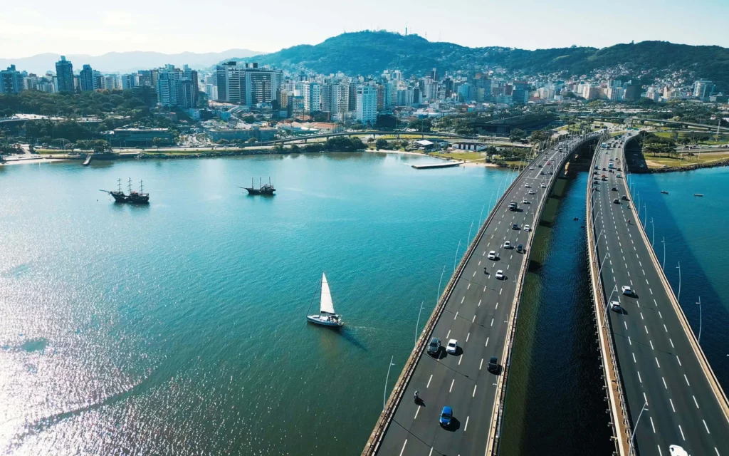 Imagem aérea da cidade de Florianópolis durante dia ensolarado para ilustrar matéria sobre as cidades mais competitivas do Brasil
