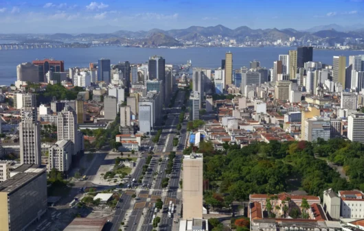 Imagem aérea de prédios com paisagem natural ao fundo, no Rio de Janeiro, para ilustrar matéria sobre as cidades mais limpas do Brasil