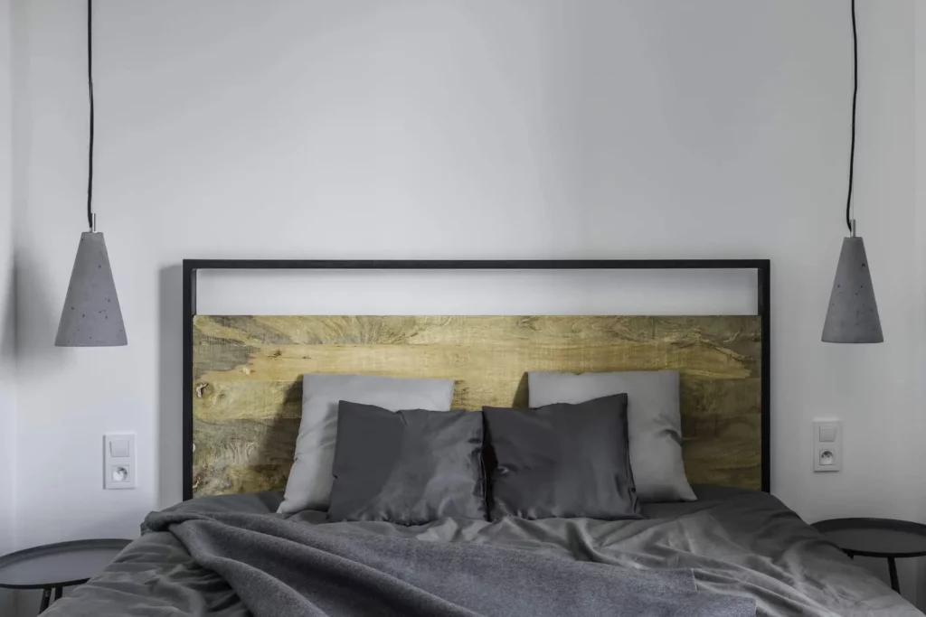 Imagem de um quarto com parede cinza-claro e uma decoração em tons de cinza escuro para ilustrar matéria sobre cores bonitas para quarto de casal