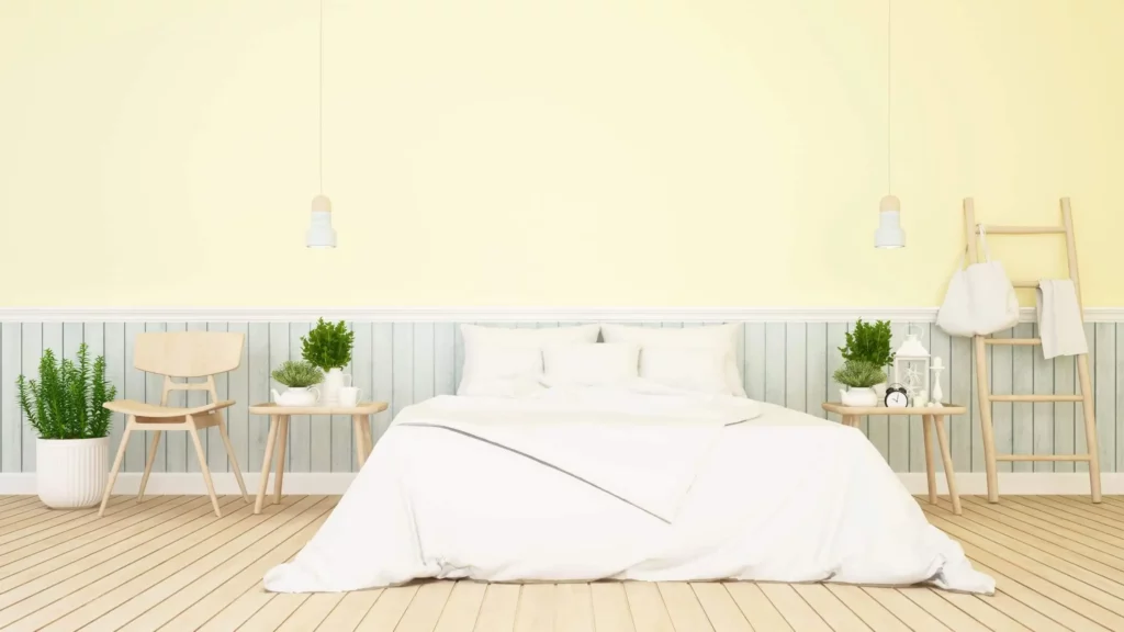 Imagem de um quarto de casal com parede amarelo-pastel para ilustrar matéria sobre cores de tinta para quarto de casal