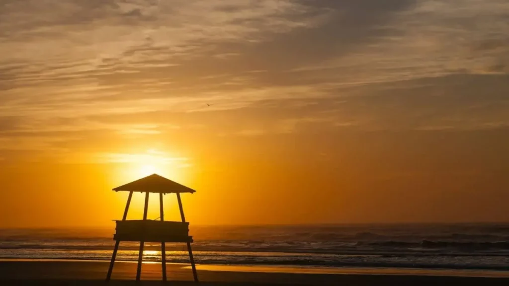 Imagem do pôr do sol em uma praia de Passo de Torres, em Santa Catarina, para ilustrar matéria sobre o crescimento populacional em cidades do Brasil
