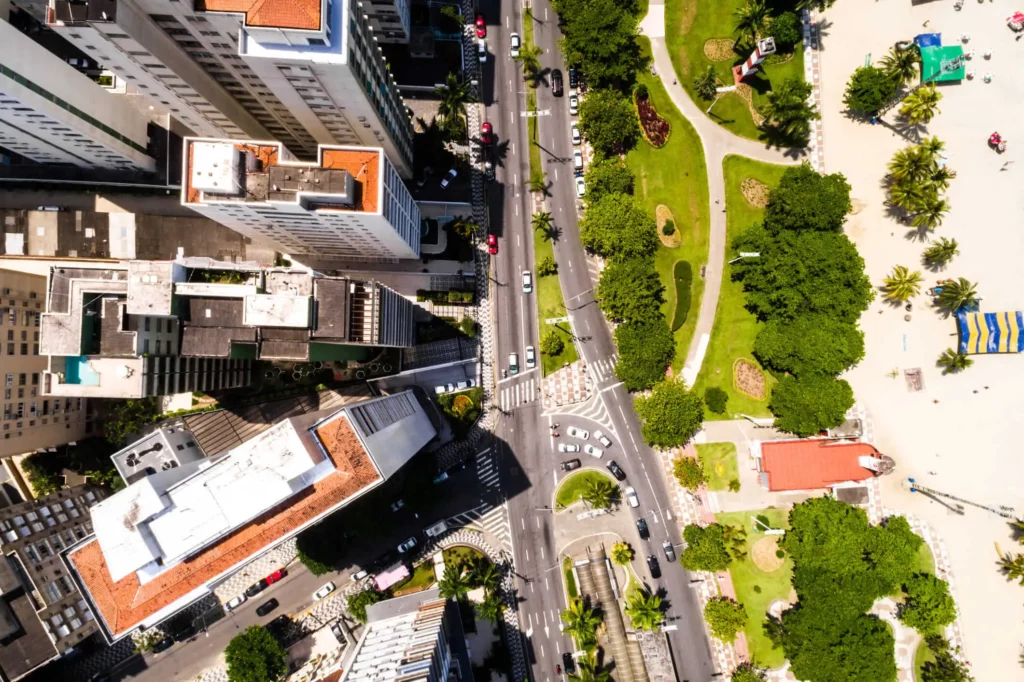 Imagem aérea da vista de Santos mostra faixa de areia, vegetação e prédios para ilustrar matéria sobre quais são as cidades mais seguras do litoral de São Paulo