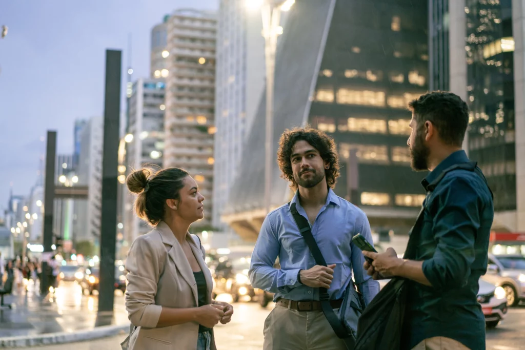 Imagem de colegas de trabalho conversando na Avenida Paulista, em São Paulo, para ilustrar matéria sobre qual a cidade com mais oportunidades de emprego no Brasil