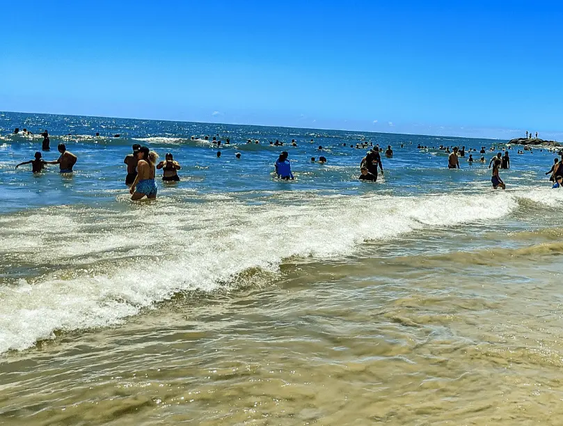 Imagem de banhistas em uma praia de Itapoá, em Santa Catarina, para ilustrar matéria sobre qual é a cidade que mais cresce no Brasil
