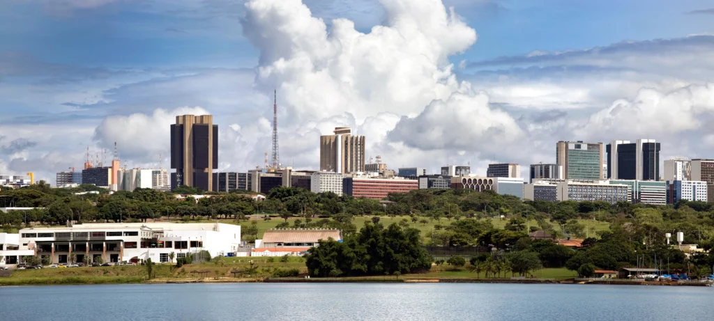 Imagem panorâmica de um dia de sol em Brasília mostra prédios, lago, céu e vegetação da cidade para ilustrar matéria sobre o ranking das cidades mais ricas do Brasil
