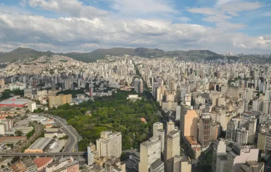 Foto que ilusta matéria sobre cidade mais populosa de Minas Gerais mostra Belo Horizonte vista do alto, com destaque para o Parque Municipal Américo Renne Giannetti em meio a prédios do Centro em primeiro plano e a Serra do Curral ao fundo (Foto: Pedro Vilela | Mtur)
