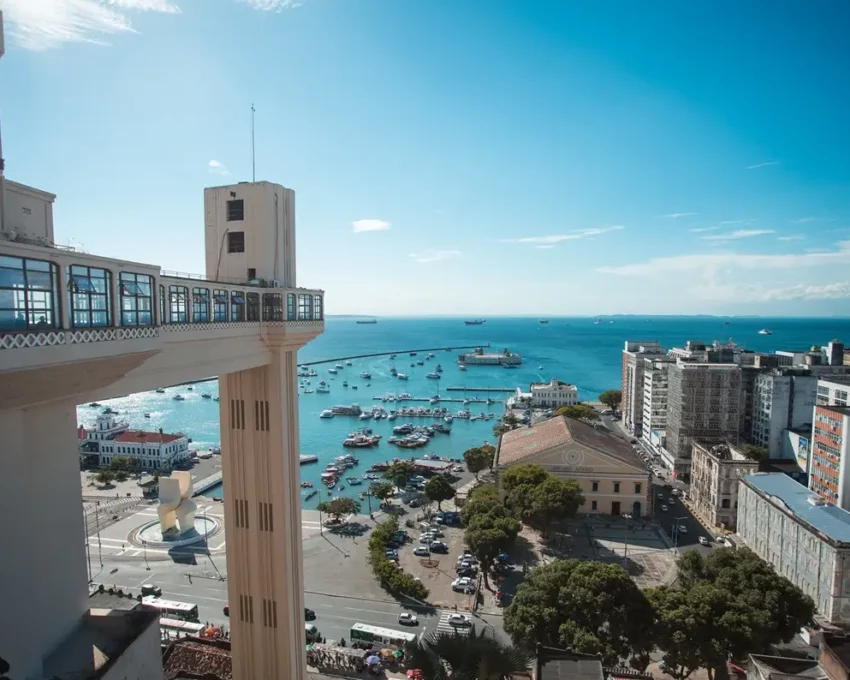 Foto que ilustra matéria sobre as Cidades mais populosas da Bahia mostra uma das vistas mais conhecidas de Salvador, com o Elevador Lacerda à esquerda, o mar no centro e prédios à direita (Foto: Márcio Filho | Mtur)