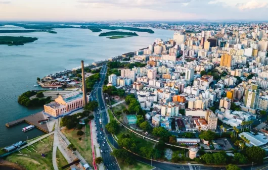 Foto que ilustra matéria sobre as Cidades mais populosas do RS mostra a cidade de Porto Alegre vista do alto, com o lago Guaíba do lado esquerdo da tela e prédios ao lado direito. (Foto: Shutterstock)