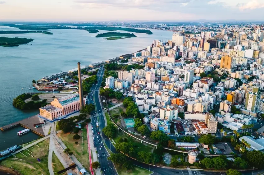 Foto que ilustra matéria sobre as Cidades mais populosas do RS mostra a cidade de Porto Alegre vista do alto, com o lago Guaíba do lado esquerdo da tela e prédios ao lado direito. (Foto: Shutterstock)