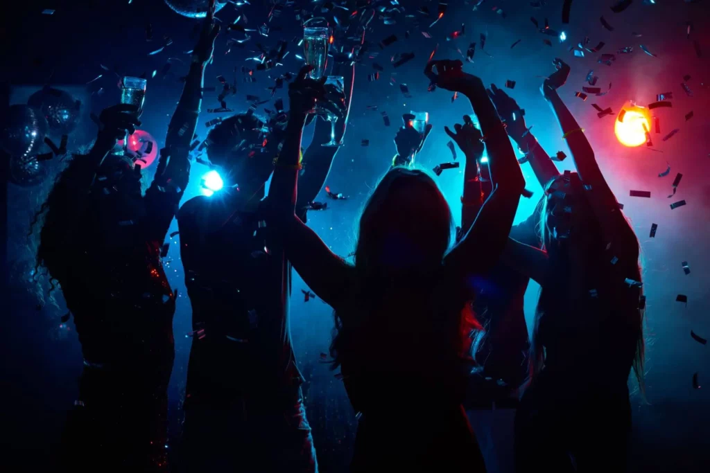 Imagem da silhueta de pessoas dançando com copo de bebida na mão em uma festa para ilustrar matéria sobre o que fazer na zona sul de Porto Alegre