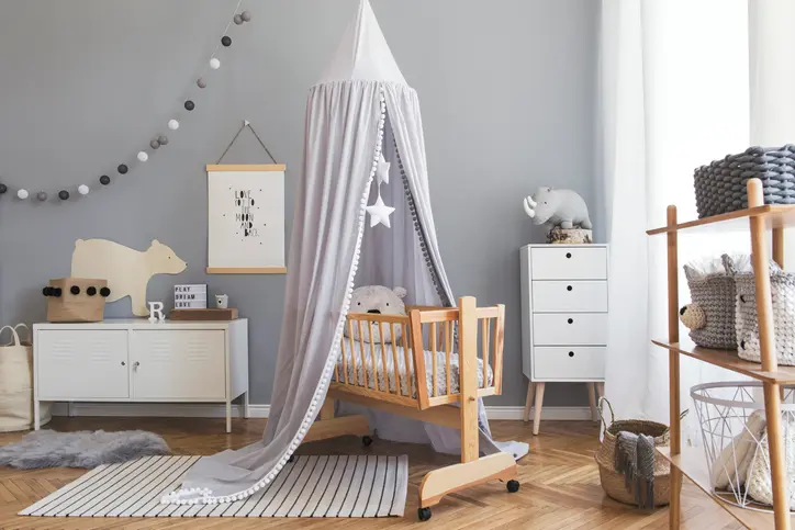 Foto de um quarto de bebê com móveis e decoração cinza-clara.