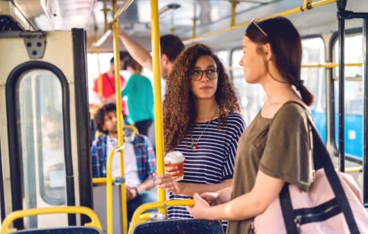Imagem de duas mulheres conversando em um ônibus para ilustrar matéria sobre os terminais de ônibus em SP