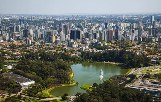 Imagem da vista aérea de São Paulo mostra lago e vegetação do Parque Ibirapuera, além de prédios ao redor, para ilustrar matéria sobre o que fazer na Zona Sul de SP